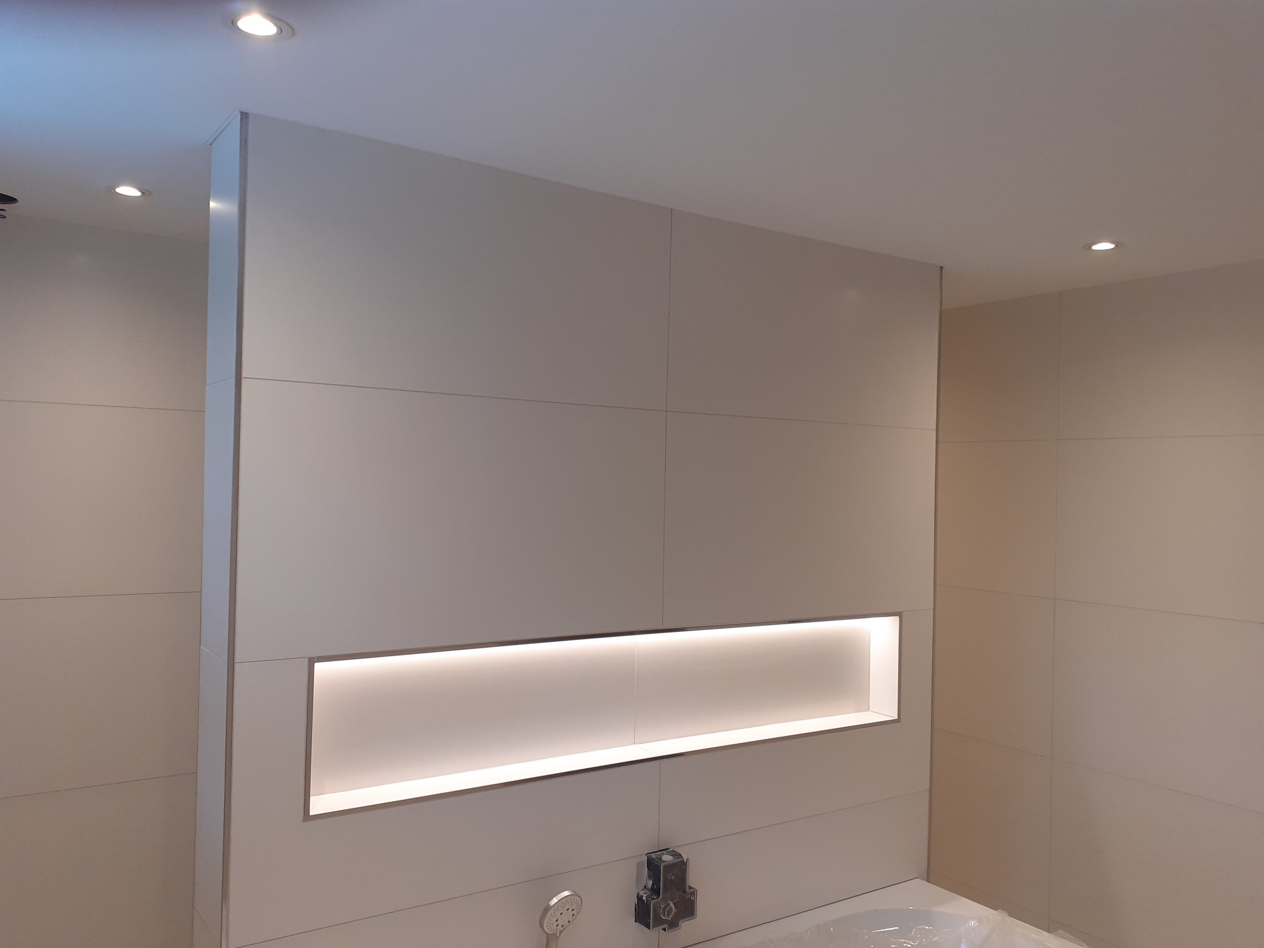 Strakke badkamer met verlichting en koof
